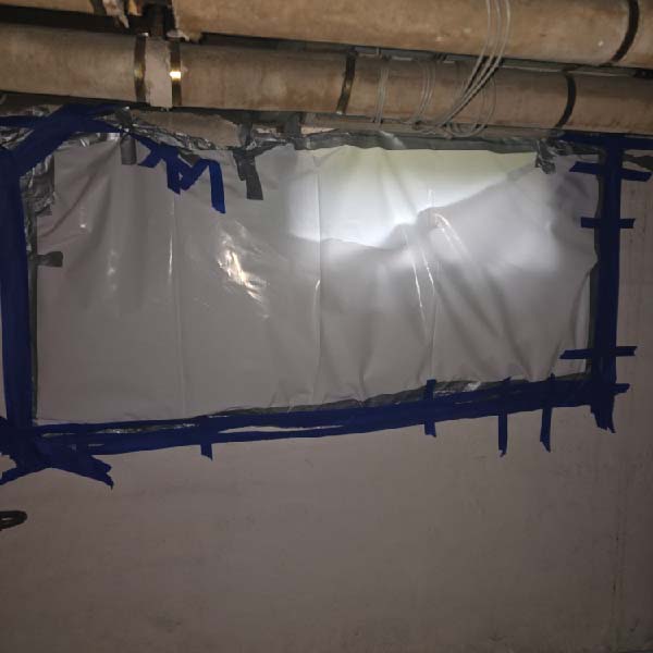 Technician sealing air ducts before asbestos removal