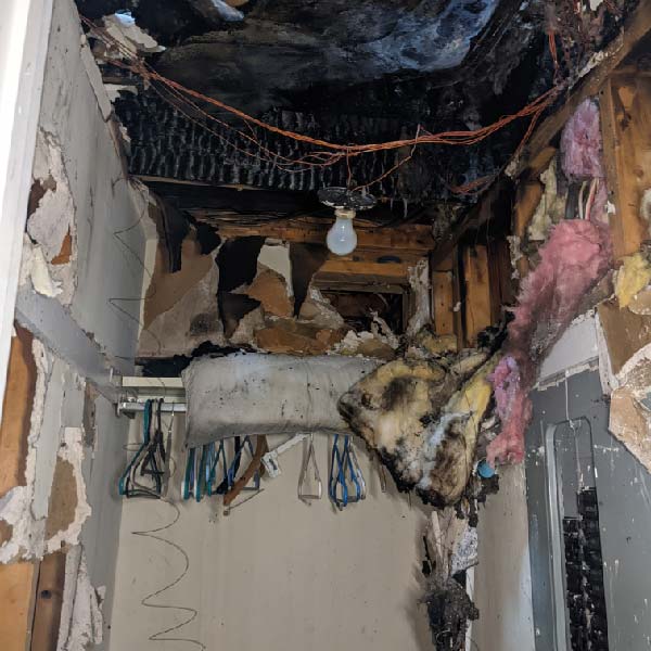 Technician assessing fire damage and securing home with board-up services